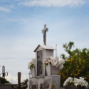 Imagem de um túmulo no cemitérios com a cruz de Cristo em cima