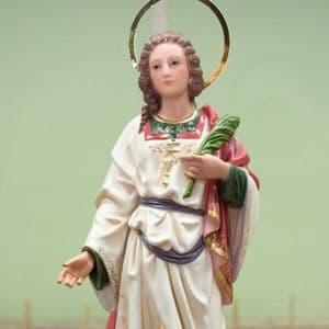 Estátua de Santa Eulália com rosto bem jovem. Possui um crucifixo ao peito e segura uma palma na mão