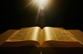 Biblia aberta sendo iluminada por raios de sol