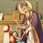 Imagem de São Brás, com vestes roxas. Possui duas velas em formato de X e impõe sobre a garganta de uma criança