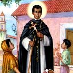 Imagem de São Martinho de Lima numa pequena aldeia com uma Igreja ao fundo. Ao lado do santo estão uma mulher a esquerda e um menino a sua direita, ambos ajoelhados. Ele veste uma roupa negra de sacerdote e segura um crucifixo na mão e possui um grande rosário que vem desde o pescoço até abaixo da cintura